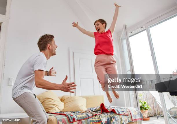 excited couple in living room at home - couple in surprise stock pictures, royalty-free photos & images
