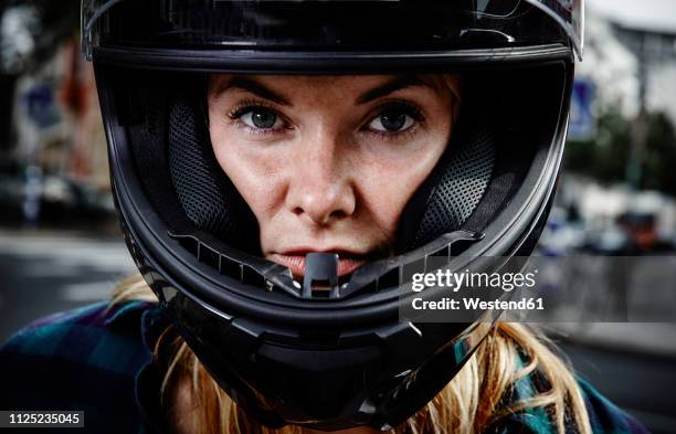 portrait of confident young woman wearing motorcycle helmet - motociclista fotografías e imágenes de stock