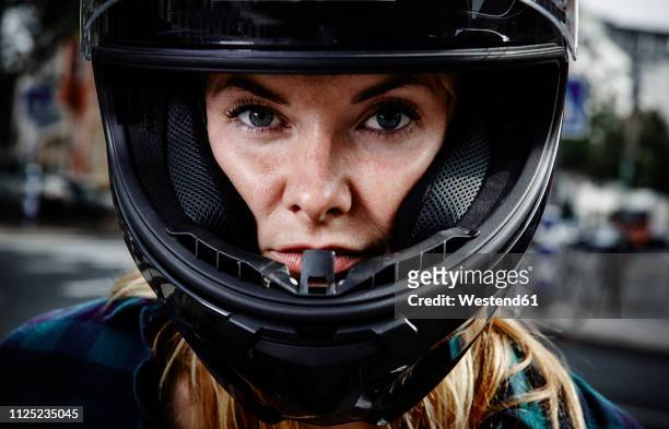 portrait of confident young woman wearing motorcycle helmet - biker helmet stock pictures, royalty-free photos & images