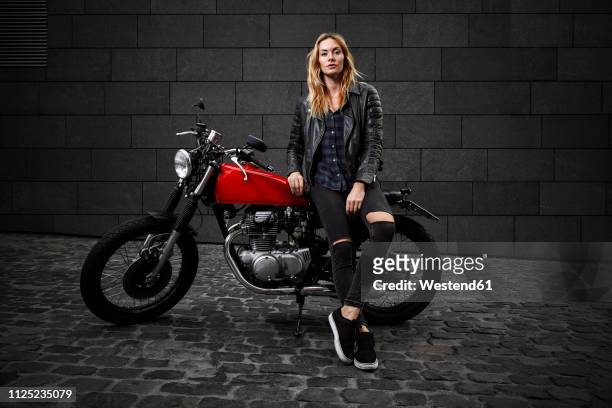 portrait of confident young woman with motorcycle - women black and white motorcycle fotografías e imágenes de stock