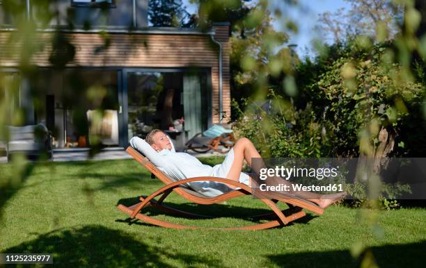 woman relaxing on deck chair in her garden - デッキチェア ストックフォトと画像