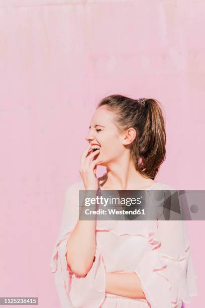 laughing young woman in front of pink wall - white blouse stock pictures, royalty-free photos & images