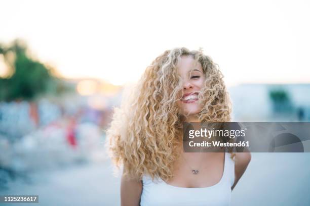 portrait of happy young woman with blond ringlets - beautiful blond hair stock pictures, royalty-free photos & images