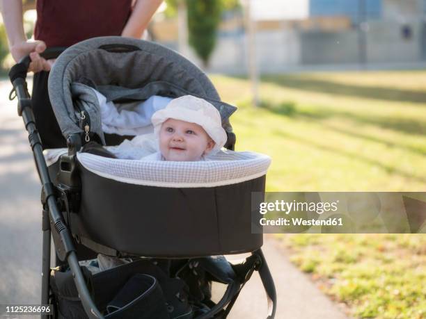 portrait of smiling baby girl in pram - baby stroller stock-fotos und bilder