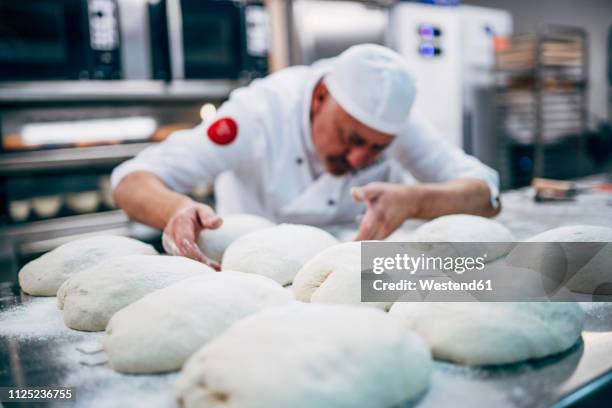 baker working with dough in bakery - baker occupation stock pictures, royalty-free photos & images