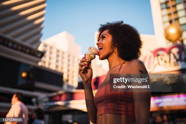 usa, nevada, las vegas, happy young woman eating ice cream in the city - las vegas city people stock pictures, royalty-free photos & images