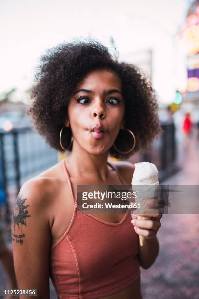 usa, nevada, las vegas, portrait of young woman holding ice cream cone grimacing - hacer muecas fotografías e imágenes de stock