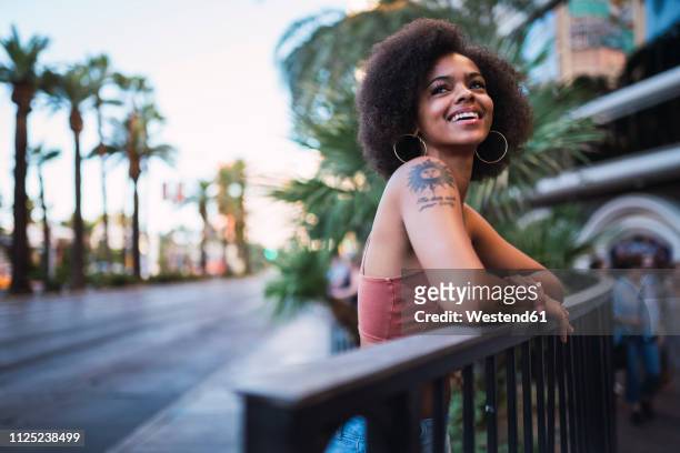 usa, nevada, las vegas, portrait of happy young woman in the city - leaning tree stock pictures, royalty-free photos & images