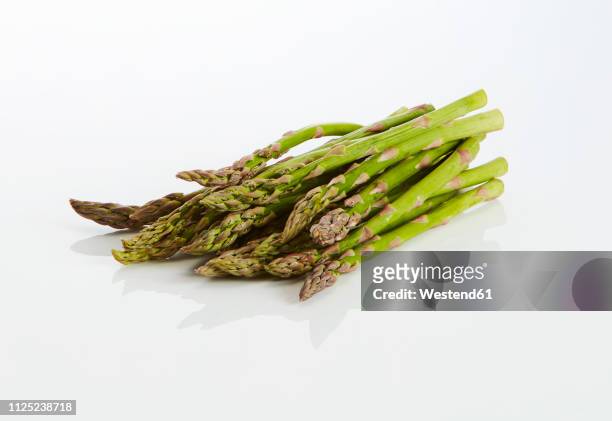 green asparagus on white ground - spargel stock-fotos und bilder