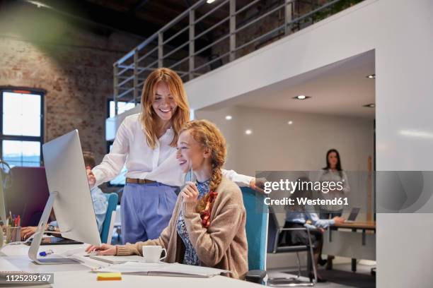 young woman working in modern creative office, colleague giving advice - colleague appreciation stock pictures, royalty-free photos & images