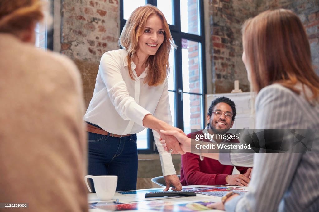 Colleagues greeting ata presentation in the office at a business meeting