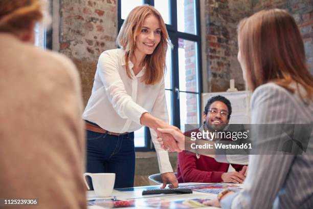 colleagues greeting ata presentation in the office at a business meeting - respect stock pictures, royalty-free photos & images