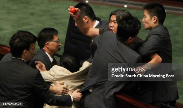 Lawmaker "Long Hair" Leung Kwok-hung is stopped by security guards as he throws tomato at Chief Executive Donald Tsang Yam-kuen in criticism of the...