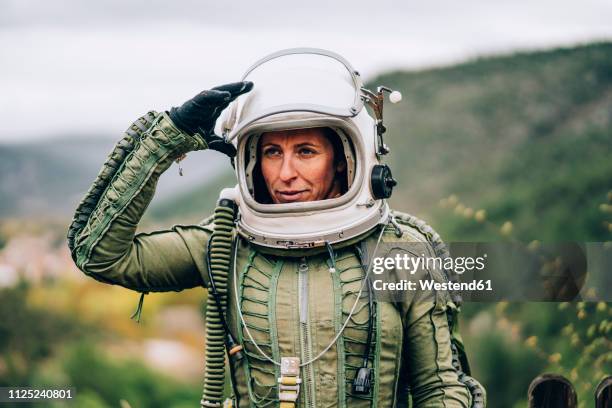 portrait of woman in space suit exploring nature - ruimtehelm stockfoto's en -beelden