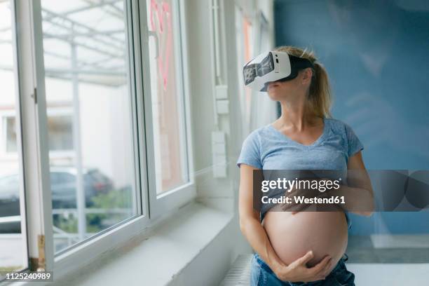 pregnant woman wearing vr glasses at the window - vr glasses bildbanksfoton och bilder