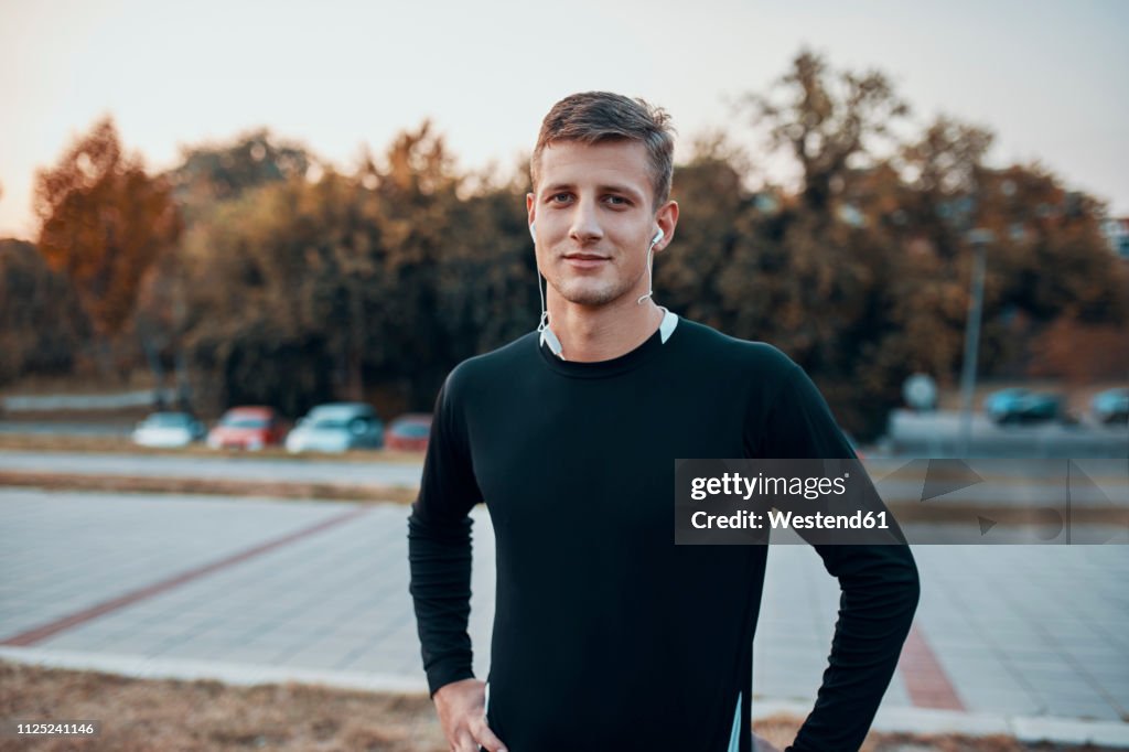 Portrait of confident sportive man outdoors in the evening