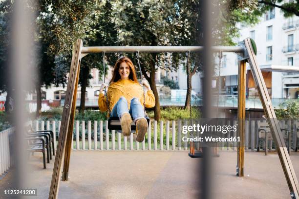 spain, barcelona, red-haired girl playing the guitar in the city - woman on swing stock-fotos und bilder