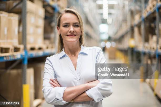 portrait of smiling woman in factory storehouse - portrait blurred background stock pictures, royalty-free photos & images