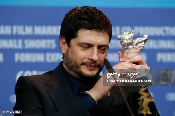 Italian director and screenwriter Claudio Giovannesi poses with the Silver Bear for best screenplay for the film "Piranhas" during a press conference...