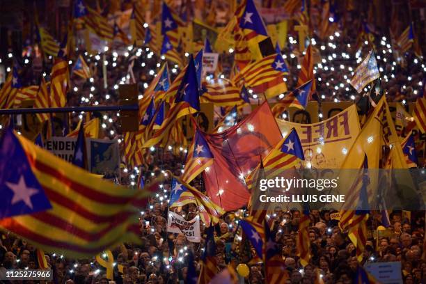 Demonstrators hold portraits of jailed Catalan separatist Oriol Junqueras and wave Catalan pro-independence Estelada flags during a protest against...