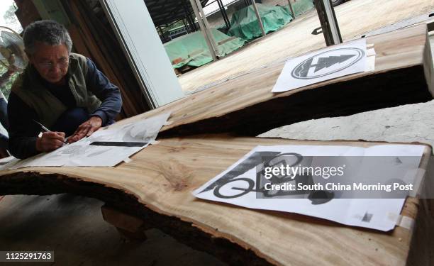 Chung Kwok-yau, senior artisan from Agriculture, Fisheries and Conservation Department , works on a tree trunk which will be turned into signs at...