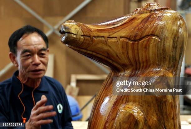 Ching Tat-mam, senior artisan from Agriculture, Fisheries and Conservation Department , explains the woodcraft crocodile "Pui Pui" made by him during...