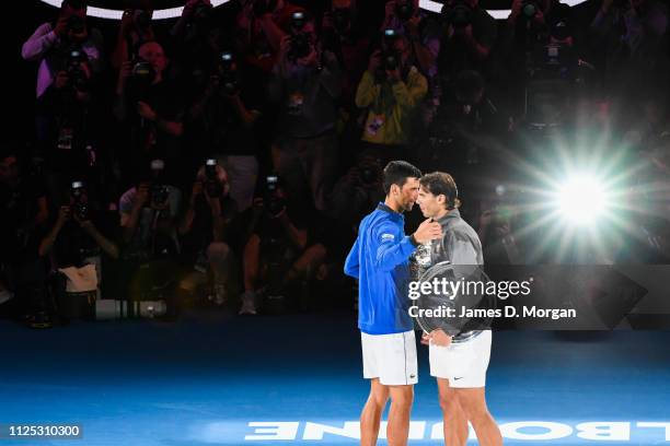 Rafael Nadal of Spain Hugging Novak Djokovic of Serbia as they pose with their trophies following victory in Djokovic's win in the Men's Singles...