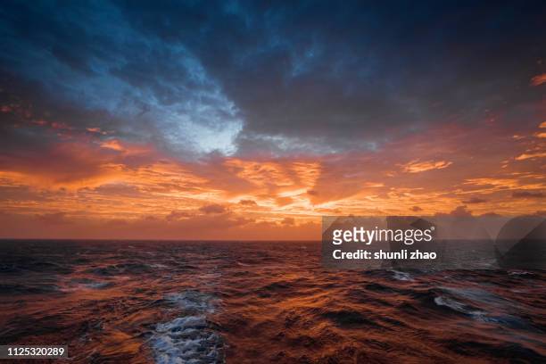 sunset on the ocean - dramatische lucht stockfoto's en -beelden