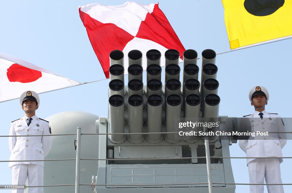 Chinese People's Liberation Army (PLA) Navy personnels stand under maritime signal flags on the deck of the Chinese naval guided missile destroyer Haikou (171) during a welcome ceremony as it docks at the Ngong Shuen Chau Naval Base in Hong Kong April 30,