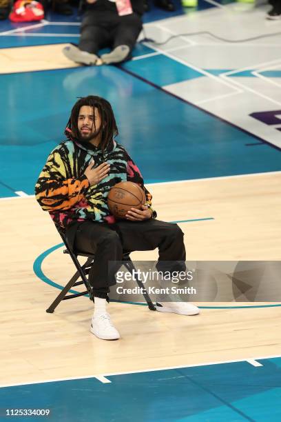 Rapper J.Cole helps out Dennis Smith Jr. #5 of the New York Knicks for his dunk during the 2019 AT&T Slam Dunk Contest as part of the State Farm...