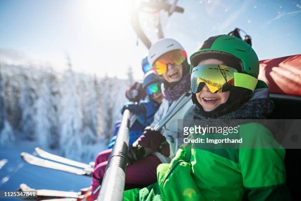familie skifahren auf sonnigen wintertag genießen - wintersport stock-fotos und bilder