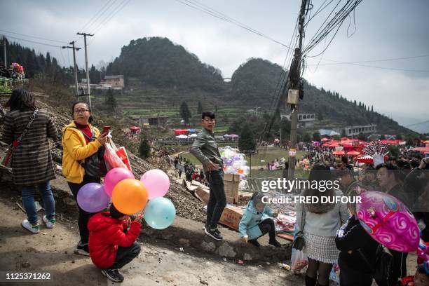 This photo taken on February 14, 2019 shows people arriving for the annual flower festival or 'Tiaohuajie' in the village of Longjia in China's...