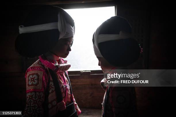 This photo taken on February 14, 2019 shows girls from the Long Horn Miao, a branch of the Miao ethnic minority group, posing with their wigs and...