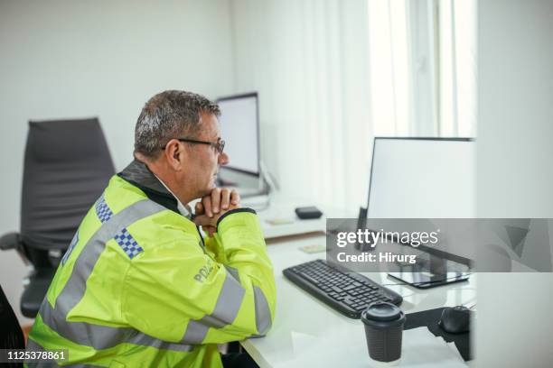 british police officer sitting at the office - police england stock pictures, royalty-free photos & images