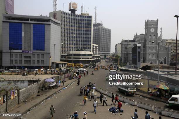 Pedestrians walk on a street in the business district in Lagos, Nigeria, on Saturday, Feb. 16, 2019. A last-minute delay of Nigerias general...