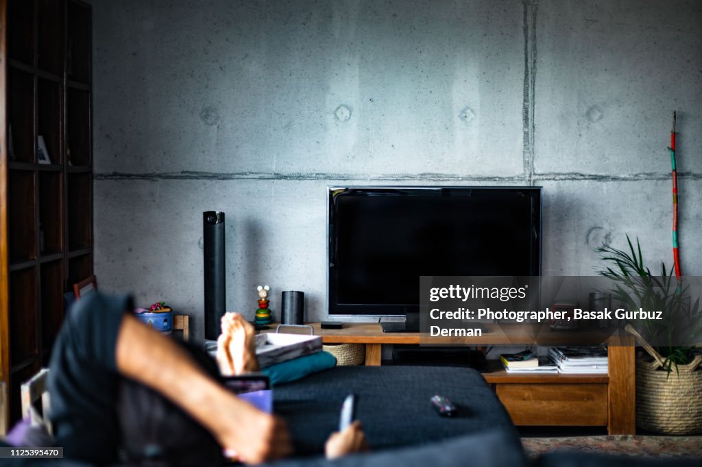 Rear view of a man watching television in a living room
