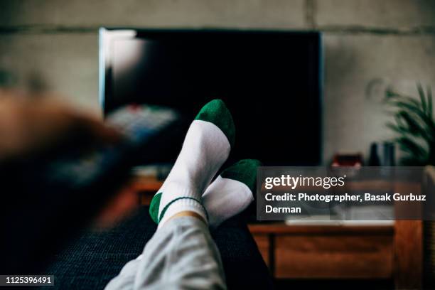 personal perspective of a woman watching television in a living room - lazy stockfoto's en -beelden