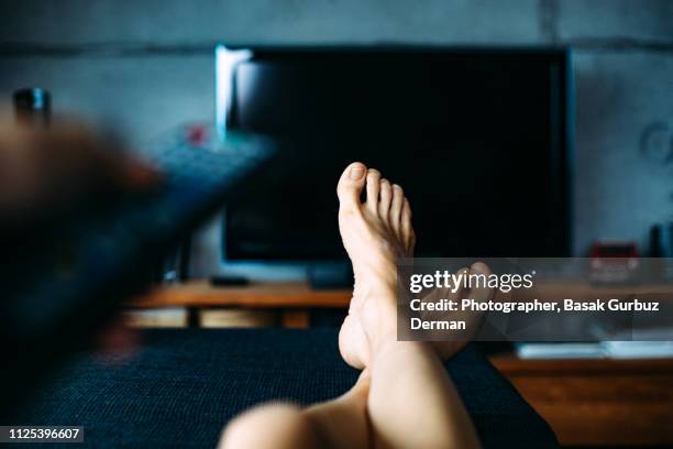 personal perspective of a woman watching television in a living room - feet up tv stock pictures, royalty-free photos & images