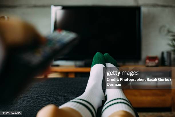 personal perspective of a woman watching television in a living room - feet up tv stock pictures, royalty-free photos & images