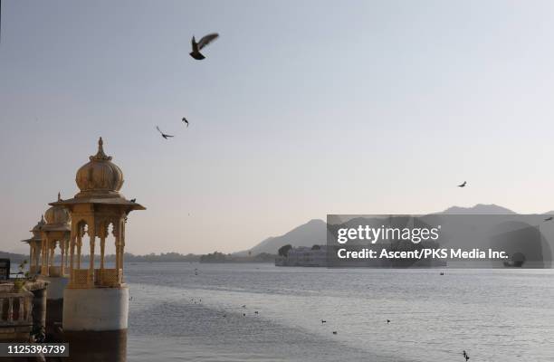 view over lake pichola and floating palace - lake palace stockfoto's en -beelden