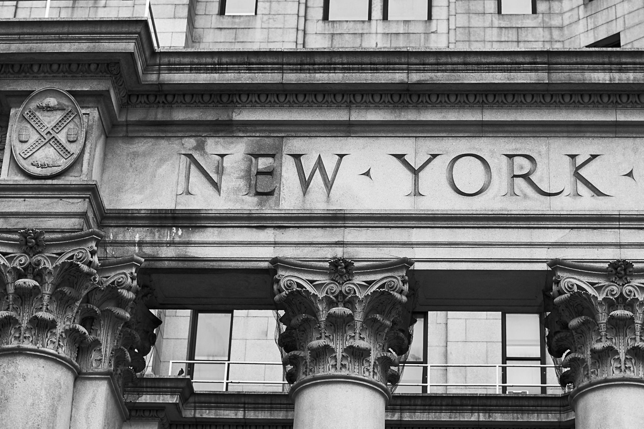 Word New York engraved on the old building facade in NYC, USA Word New York engraved on the old building facade in NYC, USA