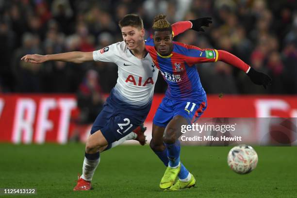 Juan Foyth of Tottenham Hotspur tangles with Wilfried Zaha of Crystal Palaceduring the FA Cup Fourth Round match between Crystal Palace and Tottenham...