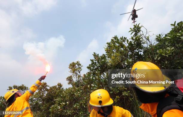 Firefighters use flare to signal their position to a Government Flying Service rescue helicopter at a inter-departmental vegetation fire cum mountain...
