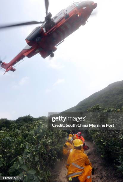 Government Flying Service helicopter picks up a wounded person at a inter-departmental vegetation fire cum mountain rescue exercise inside Tai Tam...