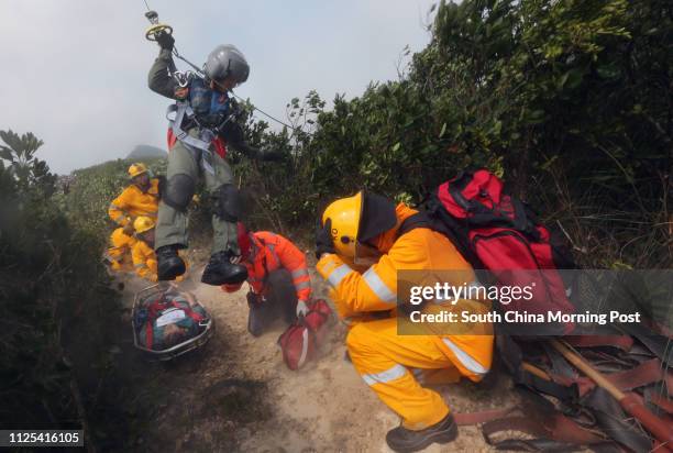 Government Flying Service officer drops down from a helicopter and pick up a wounded person at a inter-departmental vegetation fire cum mountain...