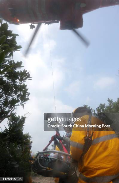 Government Flying Service officer drops down from a helicopter and pick up a wounded person at a inter-departmental vegetation fire cum mountain...