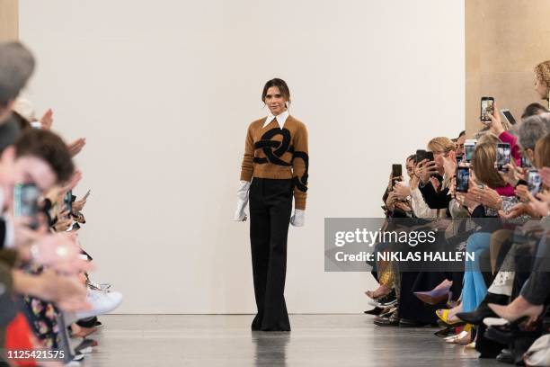 British designer Victoria Beckham acknowledges the crowd during her 2019 Autumn / Winter collection catwalk show at London Fashion Week in London on...