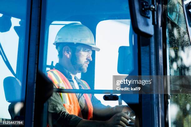 bouwvakker die een backhoe - grondverzetmachine stockfoto's en -beelden