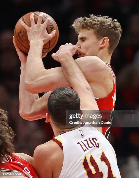 Lauri Markkanen of the Chicago Bulls is hit in the face by Ante Zizic of the Cleveland Cavaliers as he rebounds at the United Center on January 27,...