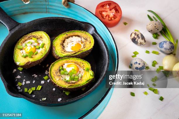 avocado baked with quail eggs - table top view - fotografias e filmes do acervo